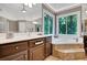 Sunlit bathroom featuring soaking tub, large windows with wooded view, and tile floors at 1170 Spring Oak Way, Cumming, GA 30041