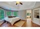 Bright bedroom with hardwood floors, tray ceilings, natural light, and ensuite bath access at 1170 Spring Oak Way, Cumming, GA 30041