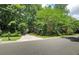Long driveway leading to a house surrounded by lush greenery, showcasing a private and secluded setting at 1170 Spring Oak Way, Cumming, GA 30041