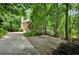 Driveway view of a home featuring a charming exterior with a paved parking area and natural surroundings at 1170 Spring Oak Way, Cumming, GA 30041
