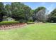 Community entrance with stone signage, manicured lawn, and colorful flowerbeds at 1170 Spring Oak Way, Cumming, GA 30041