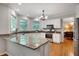 Modern kitchen with granite countertops, white cabinets, and stainless steel appliances at 1170 Spring Oak Way, Cumming, GA 30041