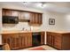 A basement kitchenette with dark cabinets, providing convenient entertaining space and functionality at 1170 Spring Oak Way, Cumming, GA 30041