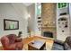 Living room with tall stone fireplace, built-in shelves, and hardwood floors at 1170 Spring Oak Way, Cumming, GA 30041