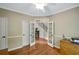 Well-lit office space with hardwood floors, offering a view of the staircase through glass paneled double doors at 1170 Spring Oak Way, Cumming, GA 30041