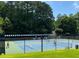 Community pickleball courts surrounded by a fence and greenery with players enjoying a game on a sunny day at 1170 Spring Oak Way, Cumming, GA 30041