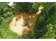 Aerial view of a playground with swings and climbing structure surrounded by lush trees at 1170 Spring Oak Way, Cumming, GA 30041