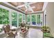 Bright sunroom surrounded by large windows offering serene views of the lush greenery at 1170 Spring Oak Way, Cumming, GA 30041