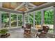 Inviting sunroom with verdant backyard views from many windows, complemented by tile flooring and comfortable seating at 1170 Spring Oak Way, Cumming, GA 30041