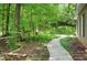 Charming walkway leading to a home with manicured landscaping, blending the house with its natural setting at 1170 Spring Oak Way, Cumming, GA 30041