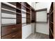 Walk-in closet with built-in dark wood shelving and drawers at 3324 Peachtree Ne Rd # 2518, Atlanta, GA 30326
