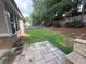 Stone patio with access to the backyard that is surrounded by lush landscaping and a wood fence at 430 La Perla Dr, Sugar Hill, GA 30518