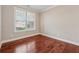 A minimalist bedroom with hardwood floors, neutral paint, and a window for natural light at 430 La Perla Dr, Sugar Hill, GA 30518