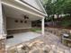 A covered patio with a ceiling fan, stone bench seating, and access to the backyard at 430 La Perla Dr, Sugar Hill, GA 30518
