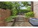 Serene patio with lush greenery, brick accents, and comfortable seating, ideal for outdoor relaxation at 2291 Falmouth Se Ct # 23, Smyrna, GA 30080