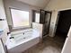 Bathroom featuring a soaking tub, a glass enclosed shower and neutral tiling at 958 Nevis Way, Mcdonough, GA 30253