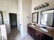 Bathroom featuring a double vanity, dark cabinets, large mirrors and modern lighting fixtures at 958 Nevis Way, Mcdonough, GA 30253