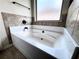 Bathroom showcasing a clean, white tub with tiled accents and natural light from the window at 958 Nevis Way, Mcdonough, GA 30253