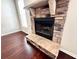 Living room showcasing a stone fireplace and mantle, complemented by rich, dark hardwood floors at 958 Nevis Way, Mcdonough, GA 30253