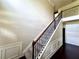 Elegant staircase featuring iron spindles, wood railing, and decorative wainscoting adding charm to this residence at 958 Nevis Way, Mcdonough, GA 30253