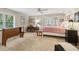 This bedroom features natural light, carpet, a desk, and a bed with a red and white patterned bedspread at 1835 Redbourne Dr, Atlanta, GA 30350