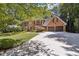 Elegant brick home with large driveway, mature trees, manicured lawn and three-car garage at 1835 Redbourne Dr, Atlanta, GA 30350