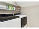 This laundry room has a washer and dryer with shelving for storage and organization at 1835 Redbourne Dr, Atlanta, GA 30350