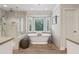 Elegant main bathroom with soaking tub, glass-enclosed shower, and natural light from bay window at 1835 Redbourne Dr, Atlanta, GA 30350