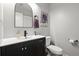 Modern powder room features a black vanity with white sink and a round top mirror at 301 Parkaire Xing, Marietta, GA 30068