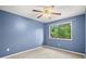 Blue bedroom with a ceiling fan, neutral carpet, and a large window with lush views at 301 Parkaire Xing, Marietta, GA 30068
