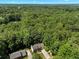 Aerial view of a house surrounded by lush greenery, showcasing its roof and driveway at 4875 Rivercliff Sw Trce, Lilburn, GA 30047