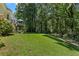 Lush backyard featuring a spacious lawn, mature trees, and a deck perfect for outdoor enjoyment at 4875 Rivercliff Sw Trce, Lilburn, GA 30047