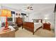 Warm bedroom design with white walls, wood furniture, a ceiling fan, and natural light at 4875 Rivercliff Sw Trce, Lilburn, GA 30047