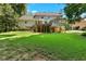 Exterior backyard view of a two-story home with a deck, patio, and manicured lawn at 4875 Rivercliff Sw Trce, Lilburn, GA 30047