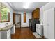Well-lit laundry room with wood floors, cabinets, a sink, a washer, and a dryer at 4875 Rivercliff Sw Trce, Lilburn, GA 30047