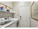 Efficient laundry room equipped with modern appliances and ample shelving, offering practicality at 606 Lorimore Pass, Canton, GA 30115