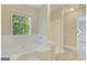 Bright bathroom features a soaking tub beneath a window, a separate shower and wood-look flooring at 1399 Cutters Mill Dr, Lithonia, GA 30058