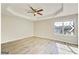 Bright bedroom with a tray ceiling, a ceiling fan, light-colored walls, and wood-look floors at 1399 Cutters Mill Dr, Lithonia, GA 30058