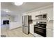 Open-concept kitchen with stainless steel appliances, white cabinets, and a view into the living area at 1399 Cutters Mill Dr, Lithonia, GA 30058