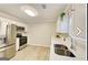 Modern kitchen with stainless steel appliances, white cabinetry, quartz countertops, and wood-look flooring at 1399 Cutters Mill Dr, Lithonia, GA 30058