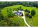 Aerial view of the home showing the swimming pool, circular driveway, and lush landscaping at 1415 N Flat Rock Rd, Douglasville, GA 30134