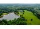 Aerial view of acreage surrounding the home with a small lake and well maintained lawn at 1415 N Flat Rock Rd, Douglasville, GA 30134