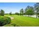 Serene backyard featuring lush greenery, a pond, and a brick pathway leading to the water at 1415 N Flat Rock Rd, Douglasville, GA 30134