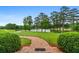 Picturesque backyard view featuring a brick walkway, pond, and verdant landscaping at 1415 N Flat Rock Rd, Douglasville, GA 30134