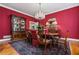 Elegant dining room with a crystal chandelier, hardwood floors, and red accent walls at 1415 N Flat Rock Rd, Douglasville, GA 30134