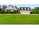 Expansive front lawn with a view of the home's three-car garage and beautifully landscaped surroundings at 1415 N Flat Rock Rd, Douglasville, GA 30134