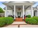Covered porch with grill and sitting area surrounded by green bushes and landscaping at 1415 N Flat Rock Rd, Douglasville, GA 30134