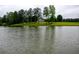 View across the lake towards a stately home nestled amongst mature trees on a sprawling estate at 1415 N Flat Rock Rd, Douglasville, GA 30134