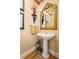 Charming powder room features decorative mirror, pedestal sink and classic decor at 1415 N Flat Rock Rd, Douglasville, GA 30134