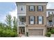 Charming two-story townhouse with brick facade, shutters, and an attached garage at 385 Rowes Cir, Alpharetta, GA 30009